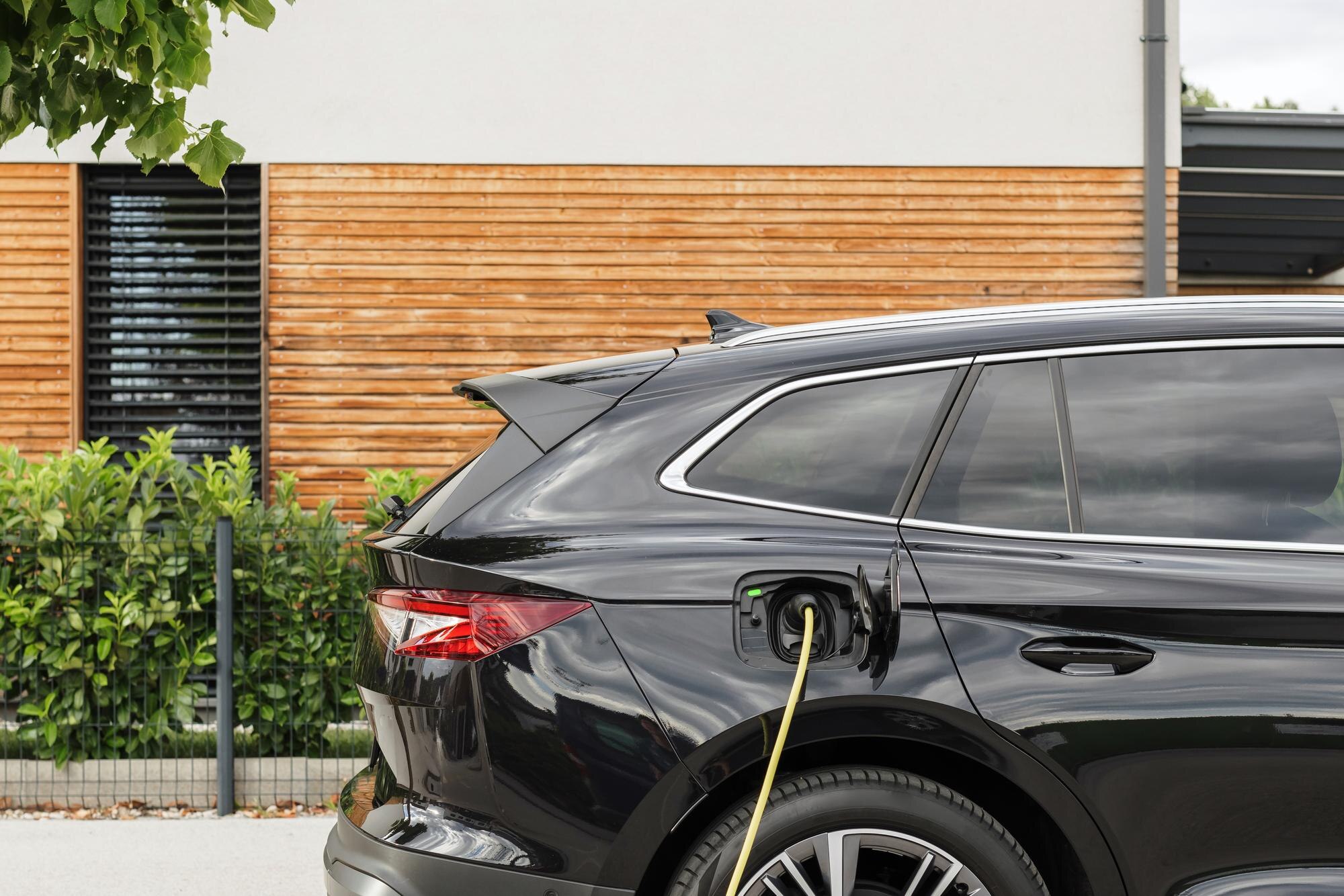 Sähköauto latauksessa kotilatausasemalla autokatoksessa.
